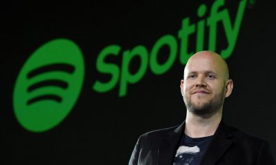 Spotify CEO standing in front of Spotify logo