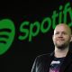 Spotify CEO standing in front of Spotify logo